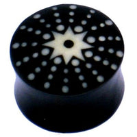 Load image into Gallery viewer, The Horn Plug schwarz weiß Stern Punkte handgeschnitzt is a black, double-flared, hand-carved buffalo horn plug featuring a white star and dot design radiating from the center on its flat end.
