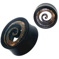 Load image into Gallery viewer, Two black round hand-carved Eisenholz Tribal Tunnel Plugs with brown spiral inlays made from buffalo horn, shown at different angles on a white background. Product: Holztunnel Spiraleninlay schwarz Büffelhorn braun Plug Expander.
