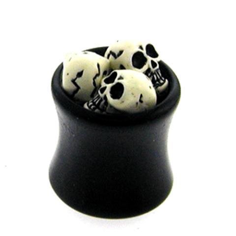 A small black cauldron filled with miniature cracked skulls, perfect for displaying your Plug Totenköpfe Tunnel Ohrstecker Ohrring Expander Dehner Piercing Ohrschmuck Unisex schwarz weiß against a white background.