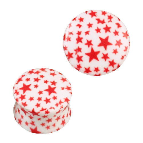 Zwei gewölbte Acryl Plugs in Weiß mit roten Sternen aus der Serie "Plug Acryl weiß mit roten Sternen gewölbt Piercing Ohrschmuck" in verschiedenen Größen – einer stehend mit sichtbarem Muster, der andere liegend für optimale Formansicht.
