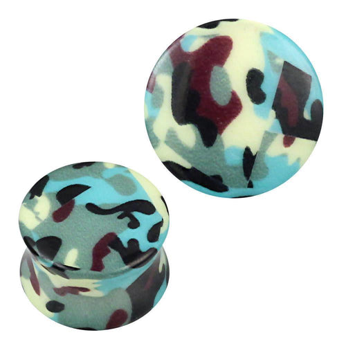 Two acrylic plugs with a green, blue, yellow, purple, and black camouflage pattern. The Plug Acryl Camouflage Muster is perfect piercing jewelry for those who love bold ear accessories; one plug stands upright while the other lies on its side.