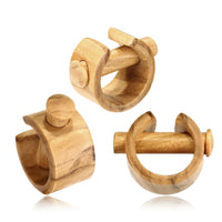 Load image into Gallery viewer, Set of three Plug Olivenholz Pin-Creole napkin rings in brown grained wood, featuring a unique cylindrical bar and circular shape design, shown on a white background.
