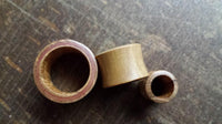 Load image into Gallery viewer, Three Flesh Tunnel Teakholz Sawoholz Rim rot double flared plugs of varying sizes, showcasing natural wood tones and visible grain patterns, are arranged side by side on a textured wooden surface.
