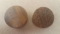 Load image into Gallery viewer, Two round wooden discs on a brown surface; the left is plain, while the right is a Flesh Plug Teakholz Peace Knoten Muster double flared Lobe Dehner in brown with an engraved geometric pattern.
