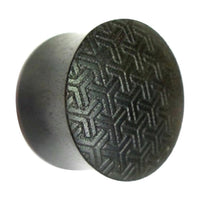 Load image into Gallery viewer, A round, dark, metallic Flesh Plug Ebenholz Peace Knoten Muster features a flat face with an intricate, interlocking Y-shaped pattern engraved on its surface and a slightly reflective finish.
