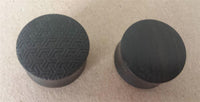 Load image into Gallery viewer, Two black “Flesh Plug Ebenholz Peace Knoten Muster” ear plugs with engraved geometric and smooth finishes are displayed on a beige surface, combining stylish ebony design and double-flared comfort.

