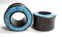 Load image into Gallery viewer, Two cylindrical Flesh Tunnel Eisenholz schwarz Rim Crushed Türkis Inlay ear plugs with flared edges and bright blue Türkis stone inlays are shown on a white background.
