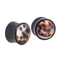 Load image into Gallery viewer, Two rounded Organic Arangholz Plugs with concave faces, inlaid with white and dark shell featuring black dot patterns, displayed side by side on a white background. Ideal as unique Tribal Muschel Lobe Piercing Plugs for a natural look.
