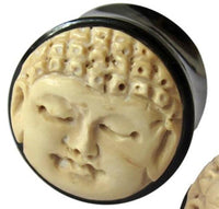 Load image into Gallery viewer, The Bio Horn Plug Buddha schwarz hell Flesh Tunnel Holz features a detailed carved Buddha face in light beige on a dark round background—ideal for Buddha piercing or flesh tunnel styles.
