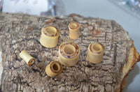 Load image into Gallery viewer, Six heller Tunnel Crocodile Holz dunkles Rangholz Inlay Tunnel Rim cylinders in different sizes are displayed on rough tree bark, with a blurred background.
