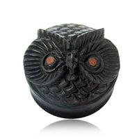 Load image into Gallery viewer, The Holz Plug Eule schwarz ist ein handgeschnitzter, runder Plug in Eulenkopf-Form mit braunen Augen und detailreichen Federmustern – organischer Schmuck, präsentiert vor weißem Hintergrund.
