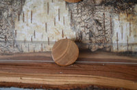 Load image into Gallery viewer, A Holz Teakholz Plug Awe Helm braun double flared is placed on a clear ruler over bark. The ruler, marked in centimeters and millimeters, shows the plug measures about 2.5 centimeters in diameter.
