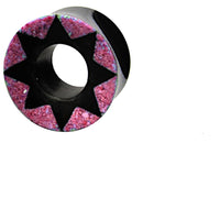 Load image into Gallery viewer, The Horn Tunnel schwarz Stern Muster pink is a hand-carved plug with a black star design in the center and a pink textured outer ring, displayed on a white background.
