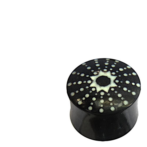 The Horn Plug schwarz weiß Stern Punkte handgeschnitzt is a hand-carved double flared plug from buffalo horn, featuring a black cylindrical shape with a white sunburst and dot pattern on top, shown on a white background.