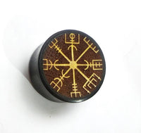 Load image into Gallery viewer, The Plug Arangholz Wikinger Kompass Inlay double flared is a round, dark wooden plug featuring a yellow-engraved Viking Vegvisir symbol on a brown top, displayed on a plain white surface.
