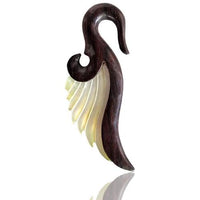 Cargar imagen en el visor de la galería, A hand-carved unisex expander pendant, the Flügel Sonoholz Perlmutt lang gelblich Tribal Piercing, features organic dark wood and a yellowish Perlmutt wing, shown on a white background.
