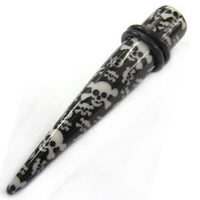 Load image into Gallery viewer, The Totenkopf Piercing Expander Dehnungsstab is a black ear stretcher with a white skull and crossbones design, two black rubber O-rings, and is the perfect unisex Ohrschmuck or unique Tunnel Plug for stylish stretching.
