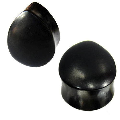 Two black, smooth, dome-shaped "Holzplug schwarz Träne" hand-carved ironwood tribal plugs are displayed against a white background.