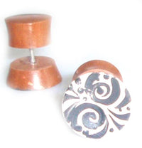 Load image into Gallery viewer, A pair of Tribal Fake Plug Holz Edelstahl Tunnel Sonoholz hand-painted 1 mm earrings: one upright with a black and white swirl, the other on its side showing the metal post—stylish fake plugs ideal as piercing expanders.
