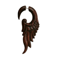 Load image into Gallery viewer, A single large fake piercing earring, hand-carved from light and dark brown sonoholz in a stylized wing shape with feather details and a stainless steel clasp.
