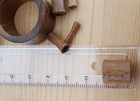 Load image into Gallery viewer, Several small, cylindrical wooden objects and a Teakholz Flesh Tunnel braun double flared Plug are placed next to a transparent ruler marked in centimeters on a light wooden surface.
